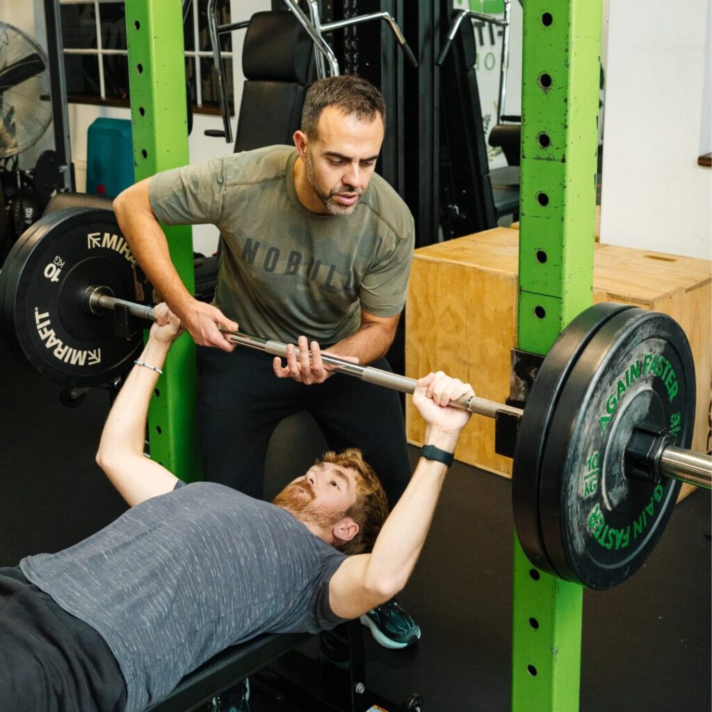 xavi gomez consulting with young guy on bench press